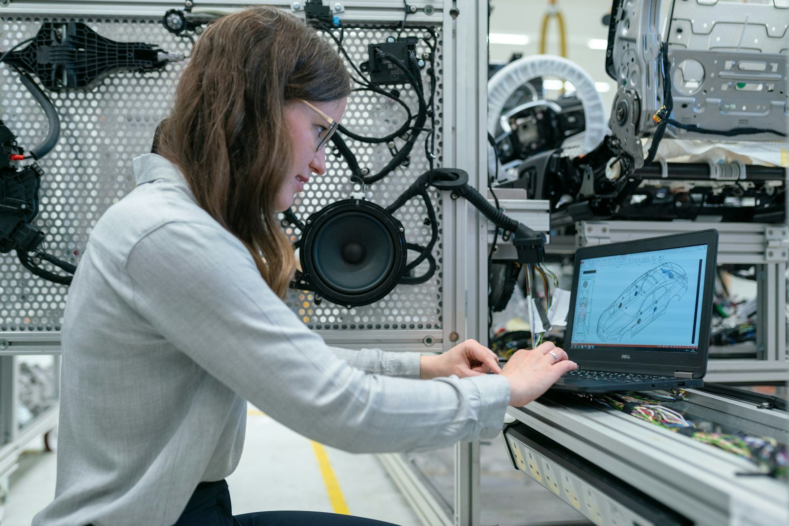 An engineering student working on a laptop beside lab equipment.